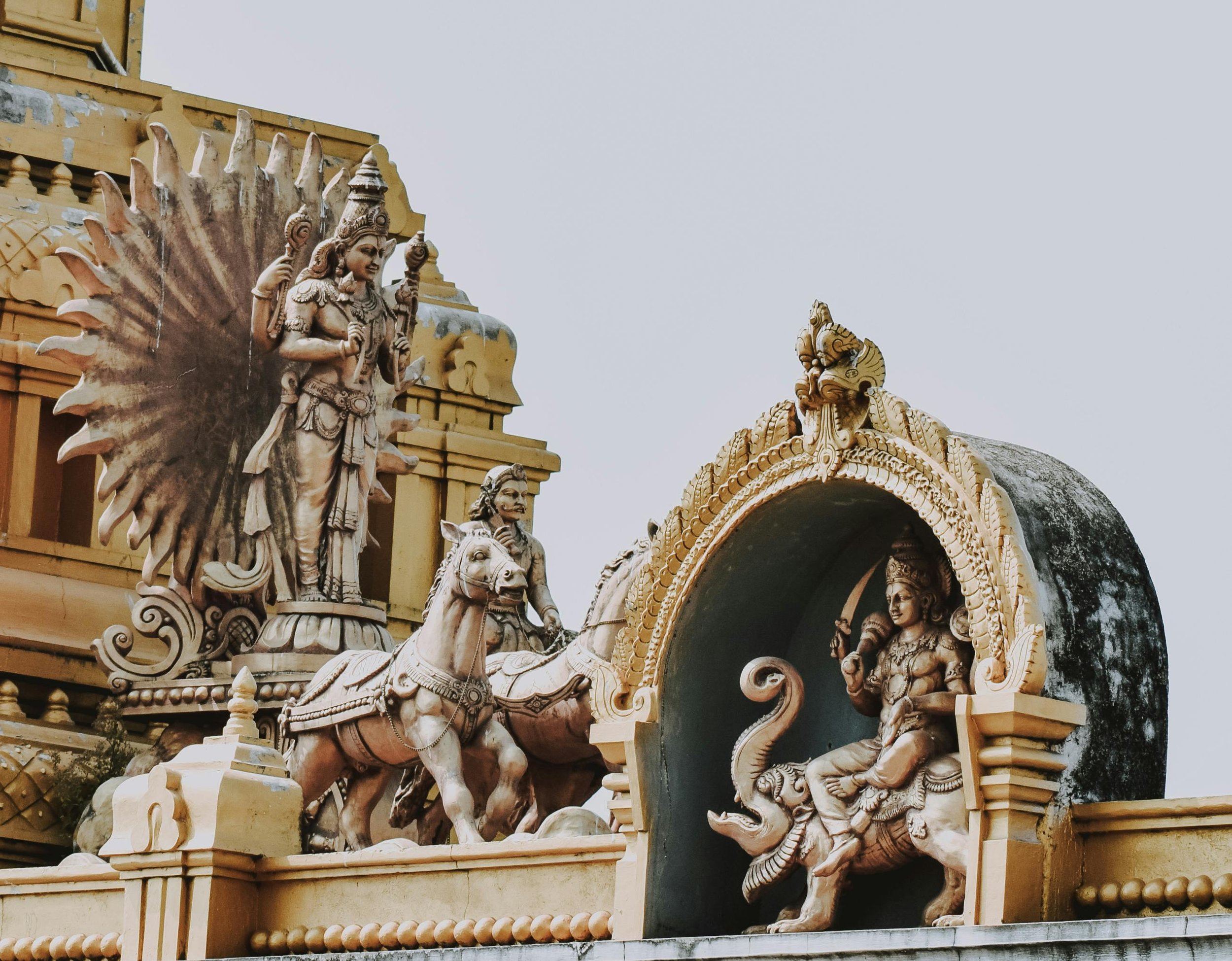Detailed sculptures of Hindu gods and Marwari horses on a temple rooftop in Rajasthan